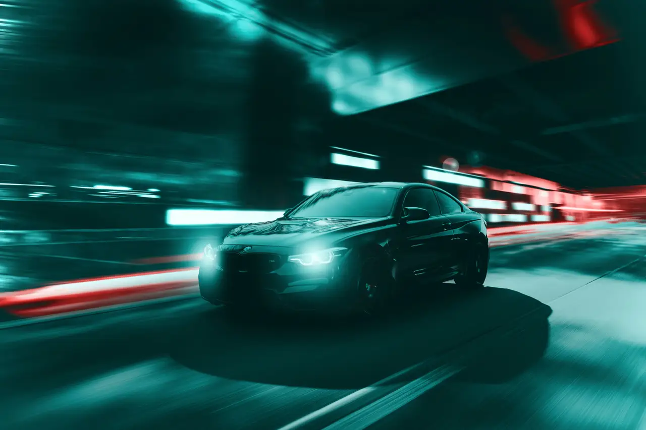 Performance car moving through electric blue and red night light