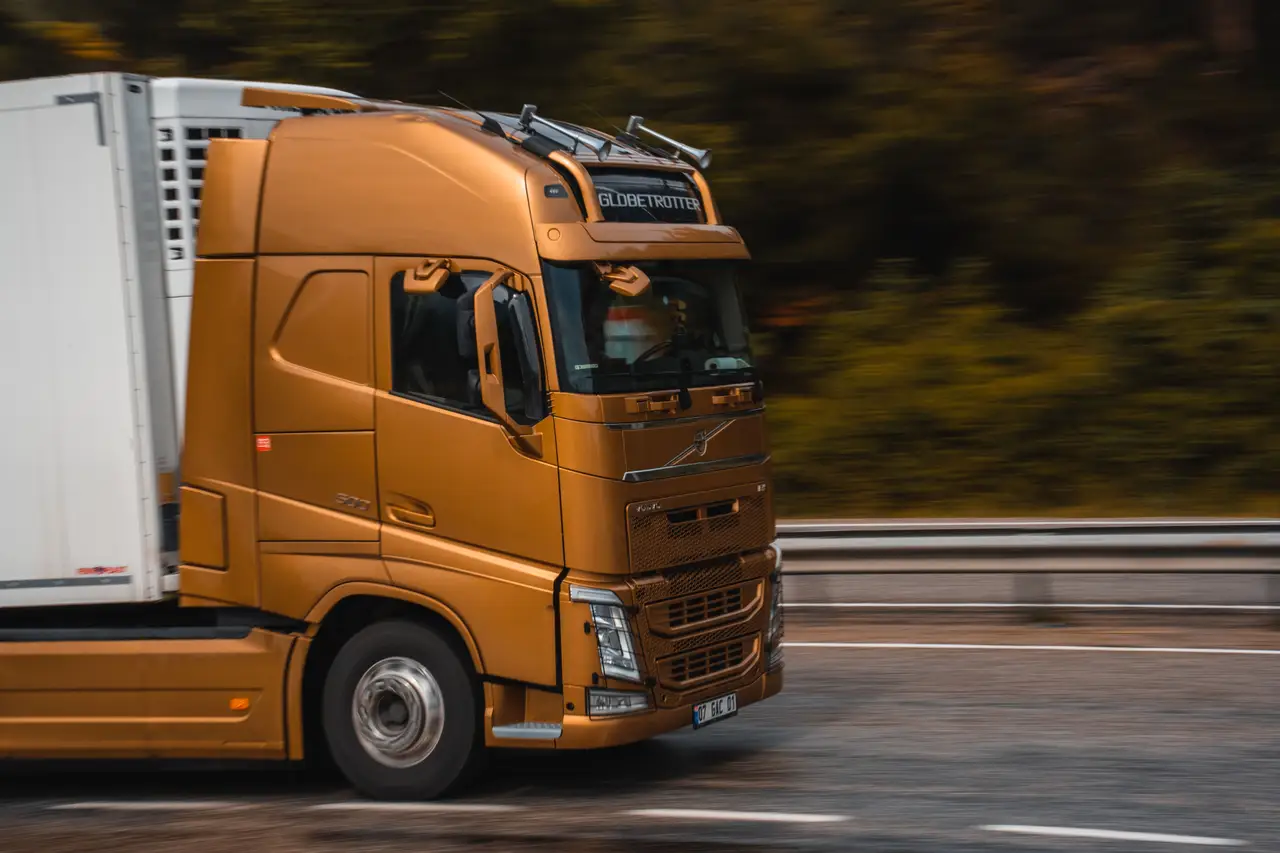 Orange HGV moving at speed on an open road
