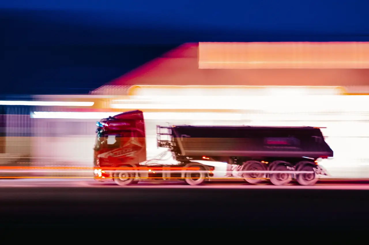 Heavy truck moving through red and blue night light